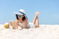 Lifestyle young asian woman relax and reading a book at the beautiful beach on holiday summer, Royalty Free Stock Photo