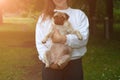 Lifestyle woman holding pug dog and smiling. Loving dog in his owner`s arms in the park. Concept of caring for a pet and Royalty Free Stock Photo