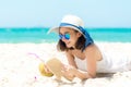 Lifestyle young  woman relax on the summer beach.  Asia tourism people reading and chill in holiday. blue sky background. Royalty Free Stock Photo