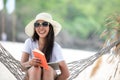 Lifestyle young woman using laptop working and reading book for relax on the beach Royalty Free Stock Photo