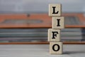 LIFO - acronym on wooden cubes on the background of a folder with documents