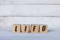 LIFO concept written on wooden cubes or blocks, on white wooden background.