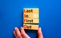 LIFO last in first out symbol. Concept words LIFO last in first out on wooden blocks. Beautiful blue table blue background.