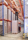 Side lift stacker operating inside large distribution warehouse with racking system Royalty Free Stock Photo