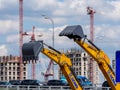 Lifted buckets of excavators XCMG against the background of the construction site. Construction fair Bauma CCT Russia Royalty Free Stock Photo