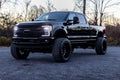 Lifted 2017 Ford F350 Platinum pick-up truck surrounded by woods