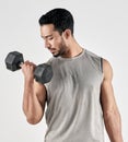 Lifting heavy and making gains. Studio shot of a muscular young man exercising with a dumbbell against a white Royalty Free Stock Photo