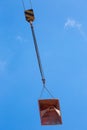 Lifting of metal pallet for dry bulk building materials on hoisting block with hook on steel chain on steel rope. Loading\
