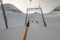 Lifting on the ski drag lift rope over sunlight near mountain peak Royalty Free Stock Photo