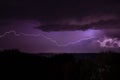 Lighning bolt over night sky in central europe. Huge lightning in a purple clouds over a night city. Storm at night Royalty Free Stock Photo