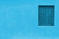 Light baby blue color facade with darker blue window and large empty blue wall