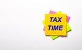 On a light background - bright multicolored stickers with the text TAX TIME. Copy space Royalty Free Stock Photo