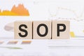 On a light background, graphs, diagrams and wooden cubes with the word SOP - standard operating procedure Royalty Free Stock Photo