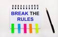 On a light background, a pen, a notebook with the text BREAK THE RULES and bright stickers Royalty Free Stock Photo