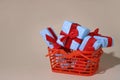 on a light background there is an orange shopping basket containing gifts in blue packaging