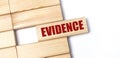 On a light background, wooden blocks with the text EVIDENCE. Close-up top view