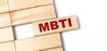 On a light background, wooden blocks with the text MBTI. Close-up top view