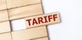 On a light background, wooden blocks with the text TARIFF. Close-up top view