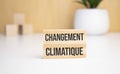 On a light background, wooden cubes and a wooden block with the text Changement climatique. View from above
