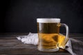 Light barley beer with foam on a gray napkin on a dark wooden background, alcoholic beverage Royalty Free Stock Photo