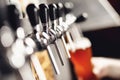 Light beer with large foam in glass against background of hand bartender