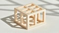 A light beige cube with a grid pattern sits on a white surface. Royalty Free Stock Photo