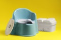 Light blue baby potty and diapers on yellow background. Toilet training Royalty Free Stock Photo