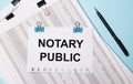 On a light blue background, documents, a pen and a sheet of paper on blue paper clips with the text NOTARY PUBLIC. Business Royalty Free Stock Photo