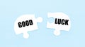 On a light blue background there are two white puzzles with the text GOOD LUCK Royalty Free Stock Photo