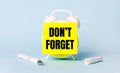 On a light blue background - a white handle and an alarm clock with a bright yellow sticker glued to it with the text DO NOT Royalty Free Stock Photo