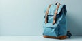 A light blue backpack with brown leather straps on a pale blue surface. Generative AI Royalty Free Stock Photo