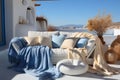 Light blue and beige terrace with sofa, blankets and pillows, at the sea, blue sky in the background. Copy space Royalty Free Stock Photo