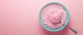 A light blue bowl filled with pink ice cream, a spoon scoops a portion, presented on a pastel pink surface, capturing the essence Royalty Free Stock Photo