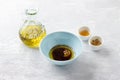 Light blue bowl with olive oil, balsamic sauce, honey, grain mustard and spices on a light gray background. Cooking homemade salad Royalty Free Stock Photo