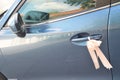 A light blue car with a light pink ribbon tied on the door handle as used for a wedding convoy