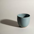Light blue ceramic cup on a plain light background casting a soft shadow Royalty Free Stock Photo