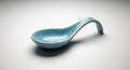 A light blue ceramic spoon featuring a curved handle and a rounded scoop. The Royalty Free Stock Photo