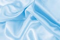 Light blue color silk wavy textile pattern as a smooth textured background. Sky colored soft satin fabric drapery. Royalty Free Stock Photo