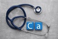 Light blue cubes with symbol Ca (Calcium) and stethoscope on gray background, top view Royalty Free Stock Photo