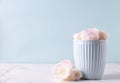 Light blue cup and  white roses flowers  in it on white marble background against blue wall Royalty Free Stock Photo