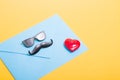 light blue envelope, red happy heart and miniature glasses with a mustache on a yellow background Royalty Free Stock Photo