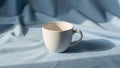 On a light blue fabric. The cup has a simple rounded shape with Royalty Free Stock Photo