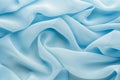 Light blue fabric draped with large folds, delicate textile background