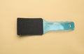 Light blue foot file on beige background, top view. Pedicure tool