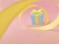 Light blue gift box at the end of the spiral yellow ribbon, pink background. Royalty Free Stock Photo