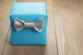 Light blue gift box with minimalistic silver ribbon bow on wooden table Royalty Free Stock Photo