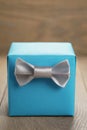 Light blue gift box with minimalistic silver ribbon bow on wooden table Royalty Free Stock Photo