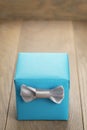 Light blue gift box with minimalistic silver ribbon bow on wooden table Royalty Free Stock Photo