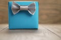 Light blue gift box with minimalistic silver ribbon bow on wooden table Royalty Free Stock Photo