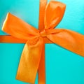 Light blue gift box with orange bow close-up. space for text, top view Royalty Free Stock Photo